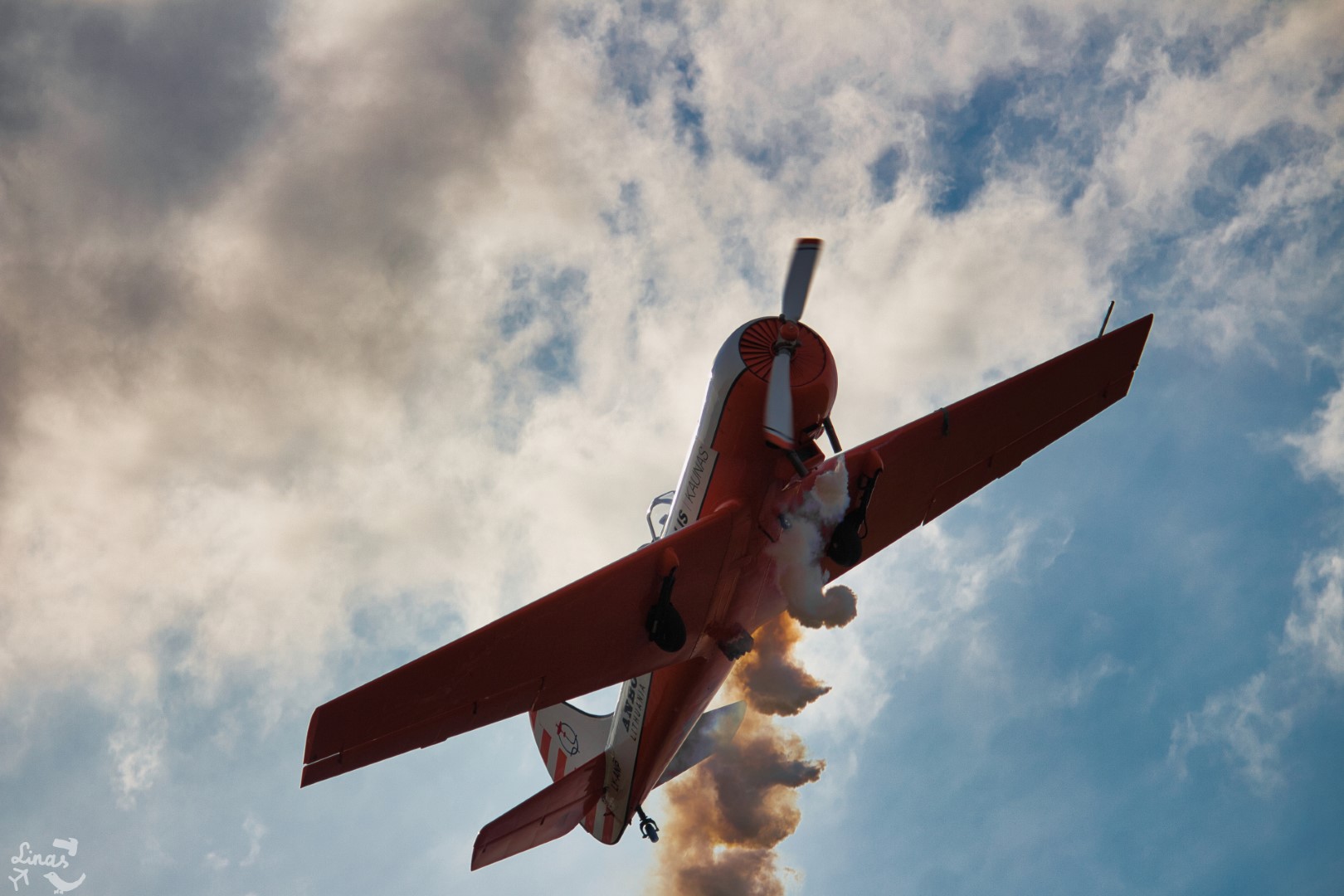 A photo of an acrobatic aircraft rolling to the right, or to the left of the camera, in a cinematic way